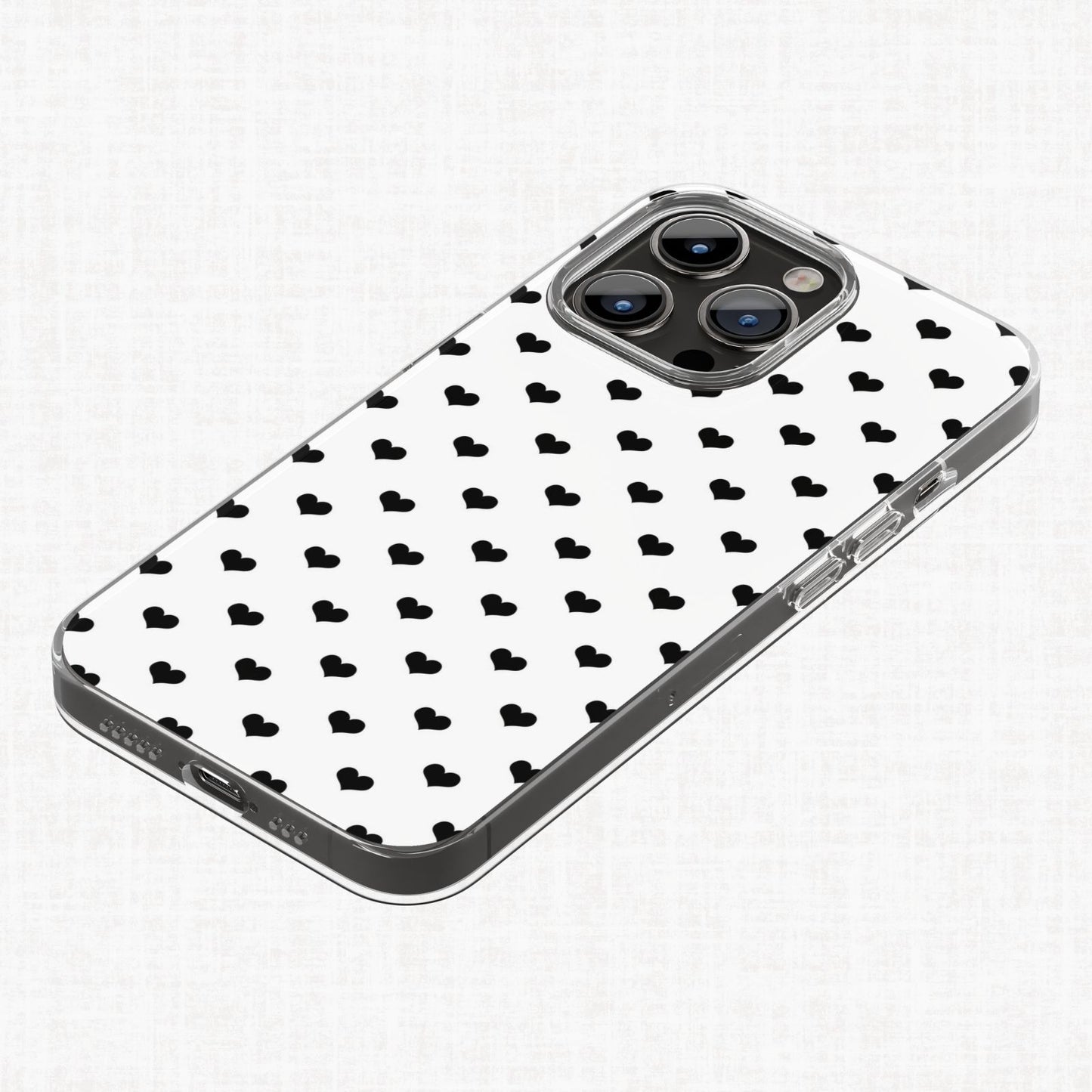 Clear phone case mockup shown with a small black heart repeating pattern on a white background from the Essential Geo digital paper collection.